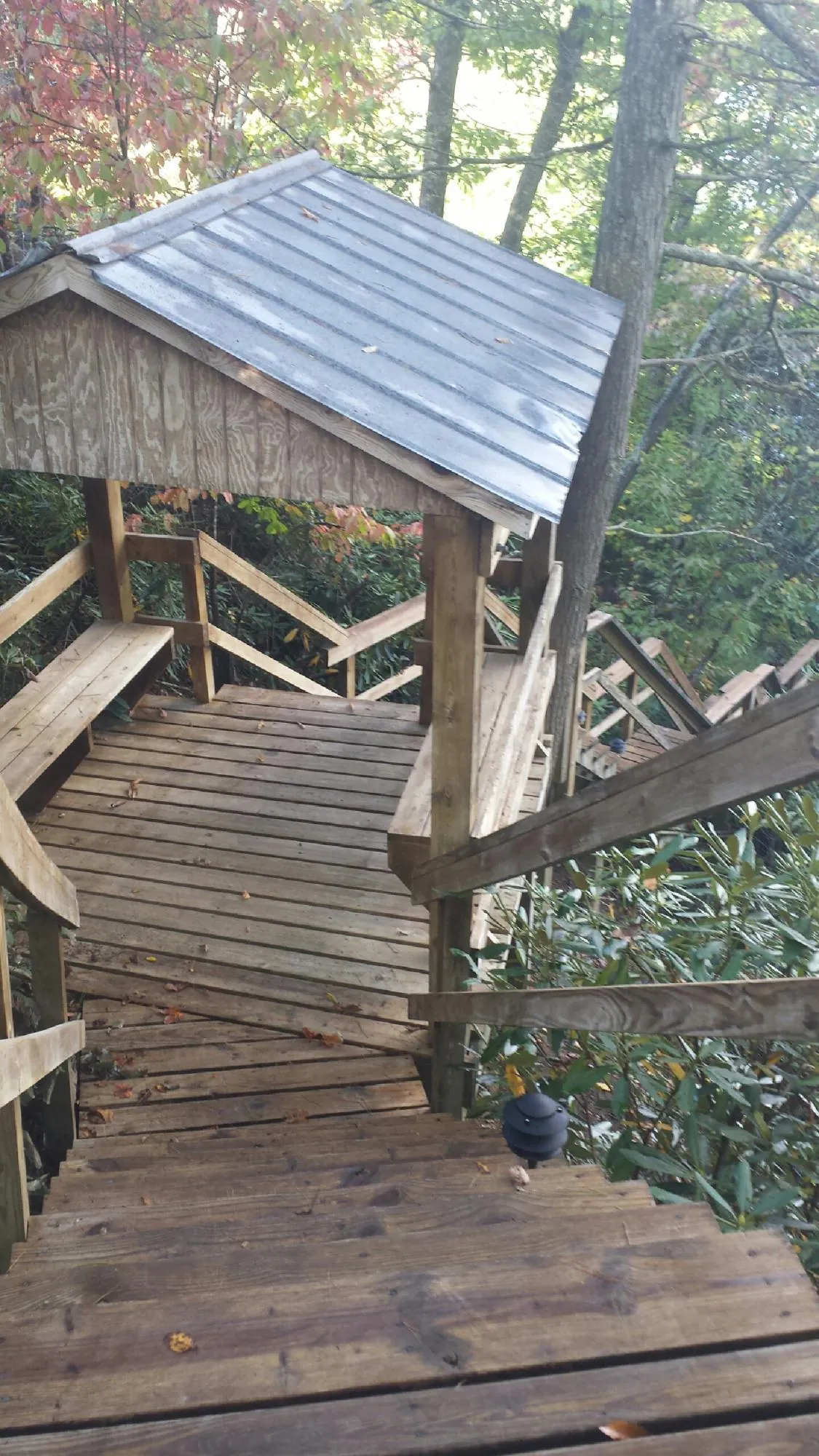 Metal roofed shelter over wooden steps on a wooded walkway — Skylight Repair & Installation work by our crew in Owensboro