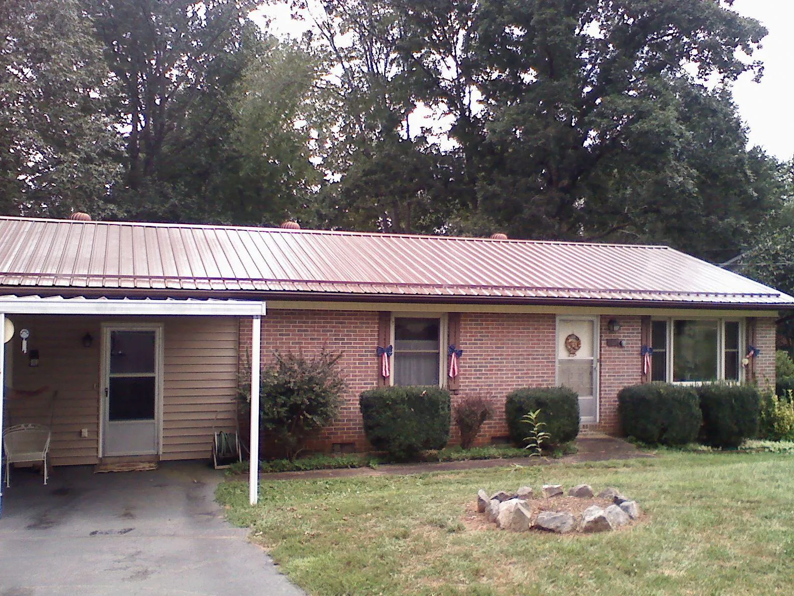 Bronze metal roof and carport on a brick ranch home — Roof Repair work by our crew in Owensboro